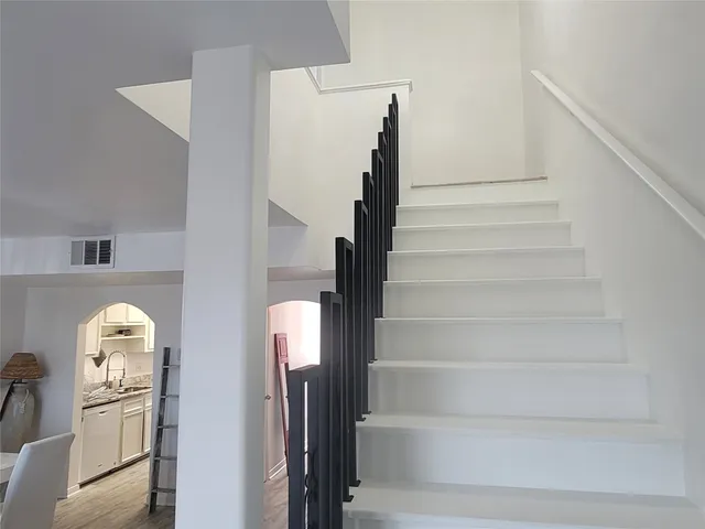a view of staircase with white walls and railing