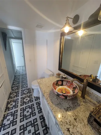 a bathroom with a granite countertop sink and a mirror