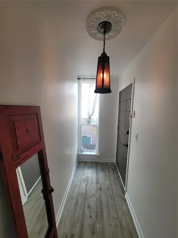 a view of a hallway with wooden floor and entryway