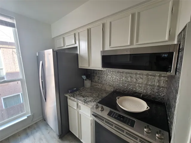 a kitchen with stainless steel appliances granite countertop a stove a refrigerator and a sink