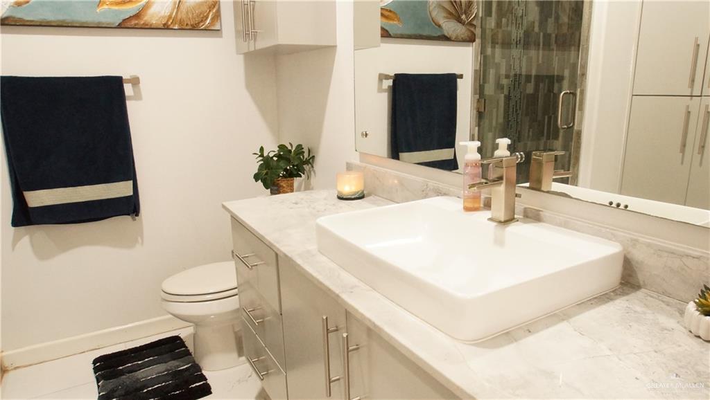 414 Ric Mar Street Edinburg, TX 78541 - Photo 32 of 36 Bathroom vanity featuring a rectangular vessel sink, brushed nickel faucet, and a light-toned countertop