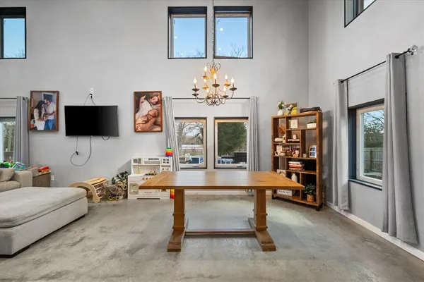 a living room with furniture a chandelier and a flat screen tv