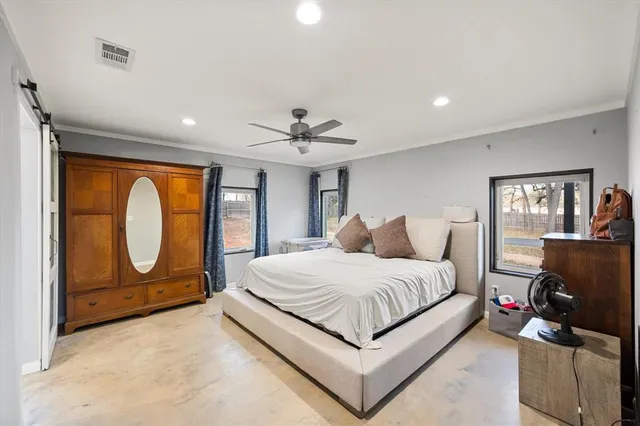 a spacious bedroom with a bed and dresser