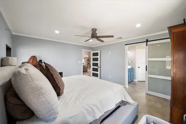 a spacious bedroom with a bed and a chandelier