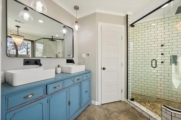 a bathroom with a shower sink and mirror