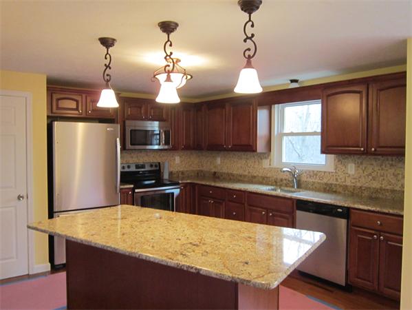 1670 Bay Road Stoughton, MA 02072 - Photo 3 of 22 a kitchen with stainless steel appliances granite countertop wooden cabinets a center island and appliances
