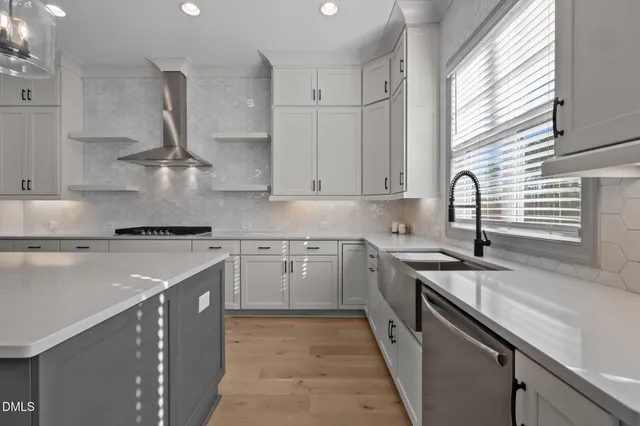 a kitchen with stainless steel appliances granite countertop a sink a stove and a refrigerator