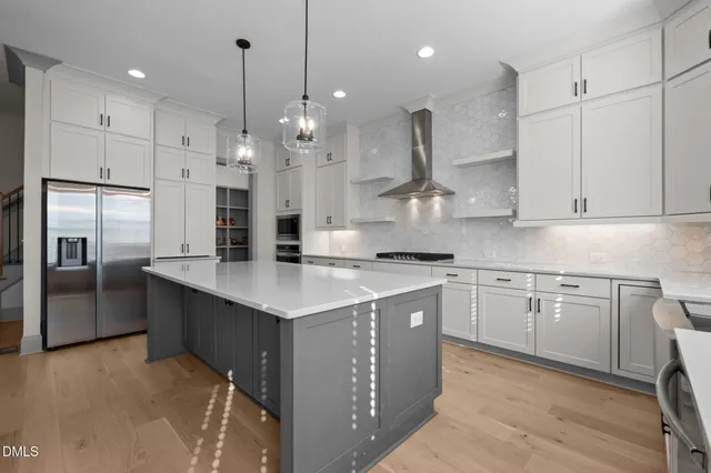 a kitchen with stainless steel appliances granite countertop a sink a refrigerator and a stove