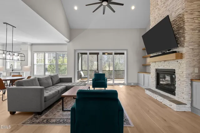 a living room with furniture a flat screen tv and a fireplace