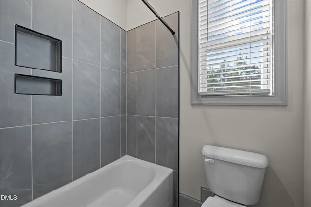 a bedroom with a bed lamp and a window