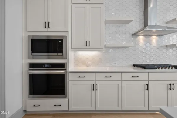 a kitchen with white cabinets and stainless steel appliances
