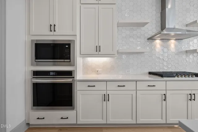 a kitchen with white cabinets and stainless steel appliances