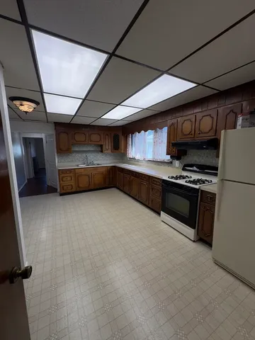 a kitchen with stainless steel appliances granite countertop a refrigerator and a stove