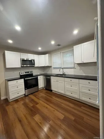 a kitchen with stainless steel appliances granite countertop a stove and cabinets