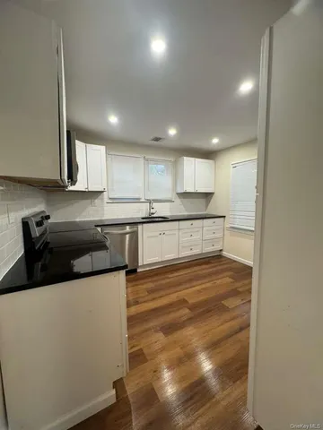 a large kitchen with stainless steel appliances granite countertop a stove a sink and a refrigerator