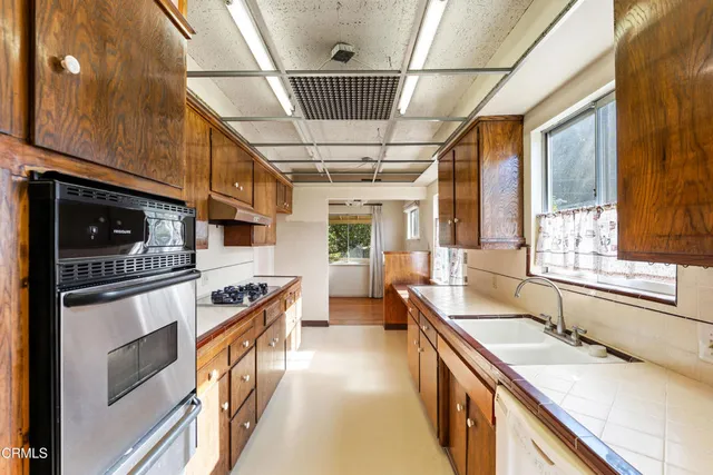 a kitchen with stainless steel appliances a sink stove and cabinets