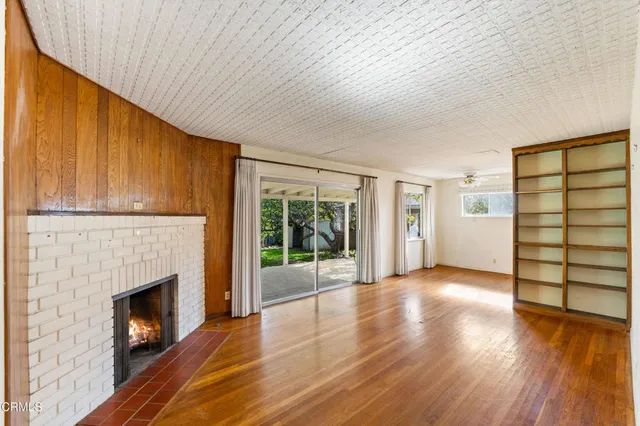 a view of empty room with wooden floor and fireplace