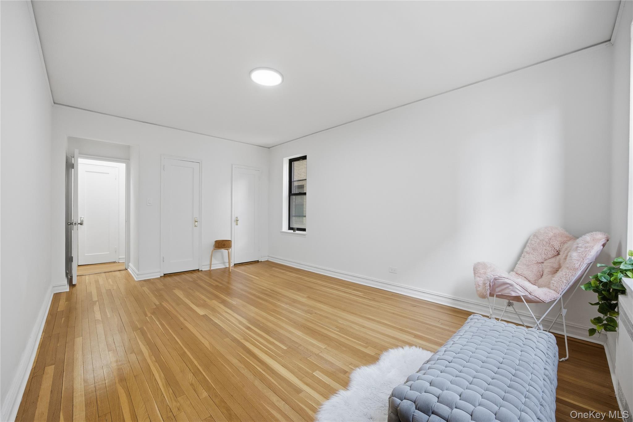 35-35 75th Street, Unit 324 Queens, NY 11372 - Photo 14 of 22 a bedroom with a bed and a table