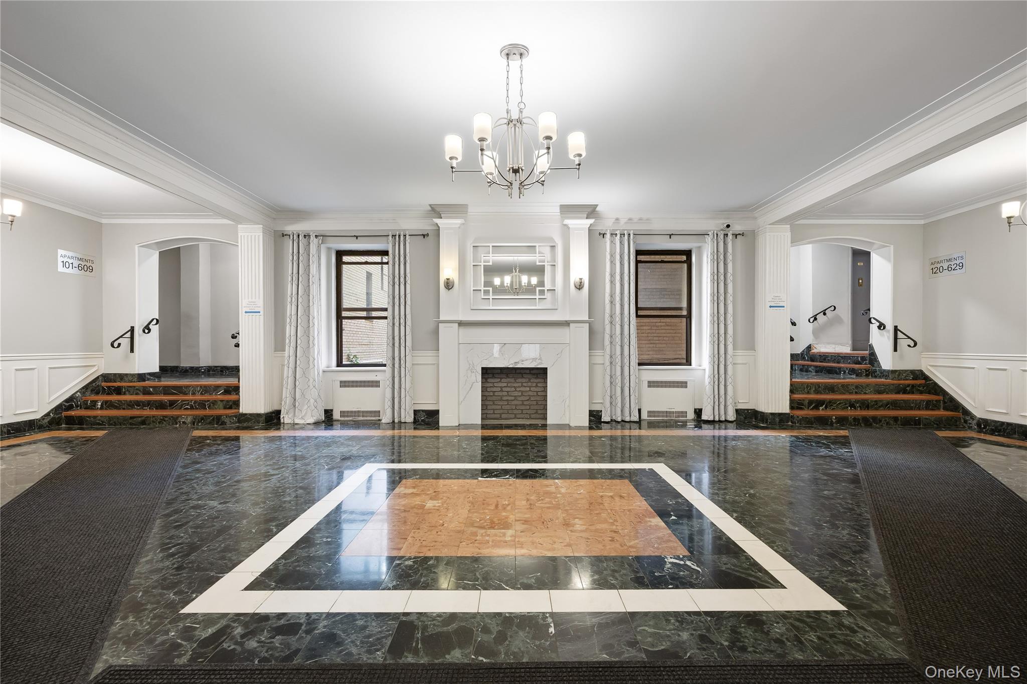 35-35 75th Street, Unit 324 Queens, NY 11372 - Photo 17 of 22 a living room with fireplace furniture and a chandelier