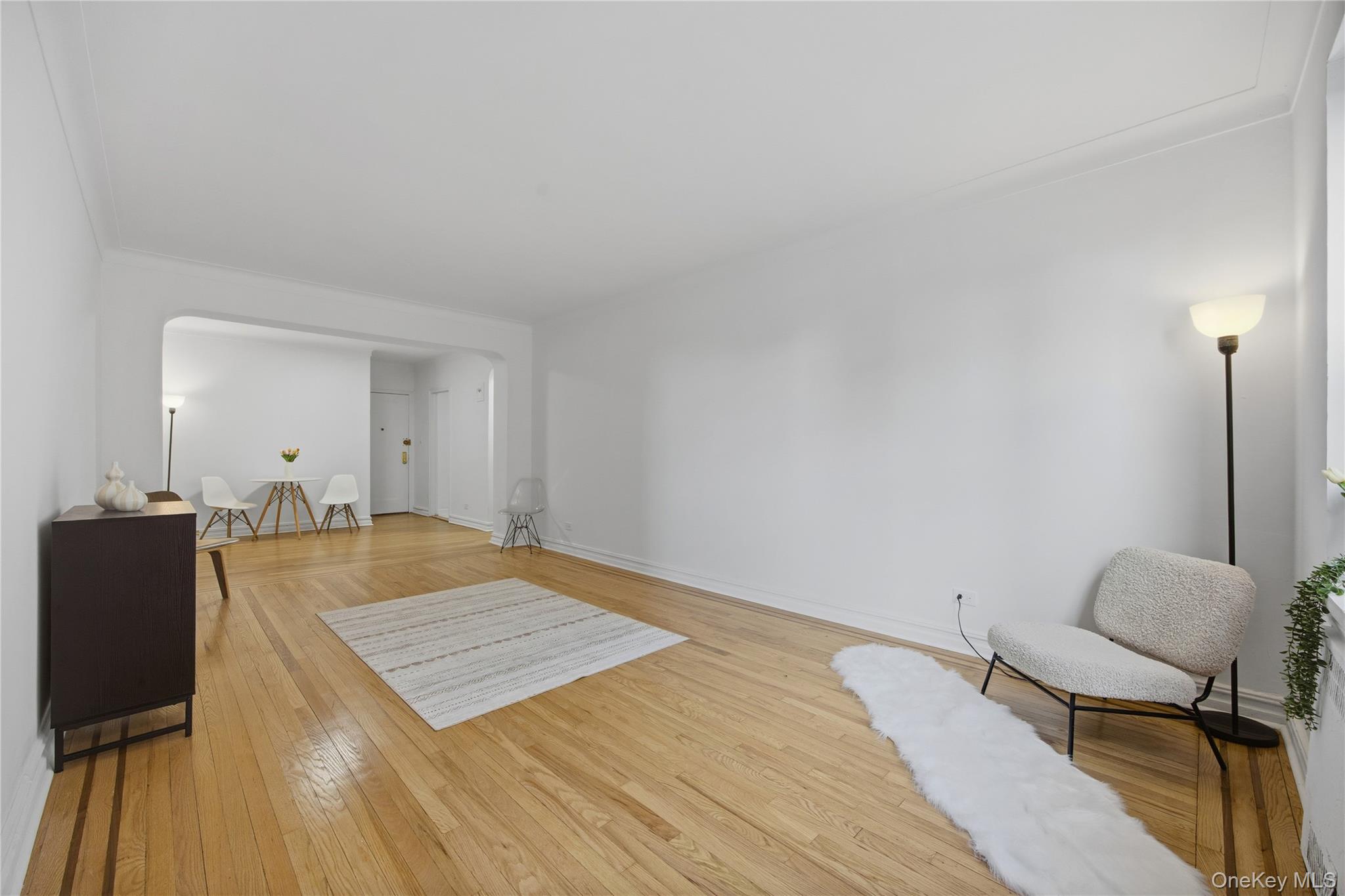 35-35 75th Street, Unit 324 Queens, NY 11372 - Photo 7 of 22 a living room with a bed furniture and a wooden floor