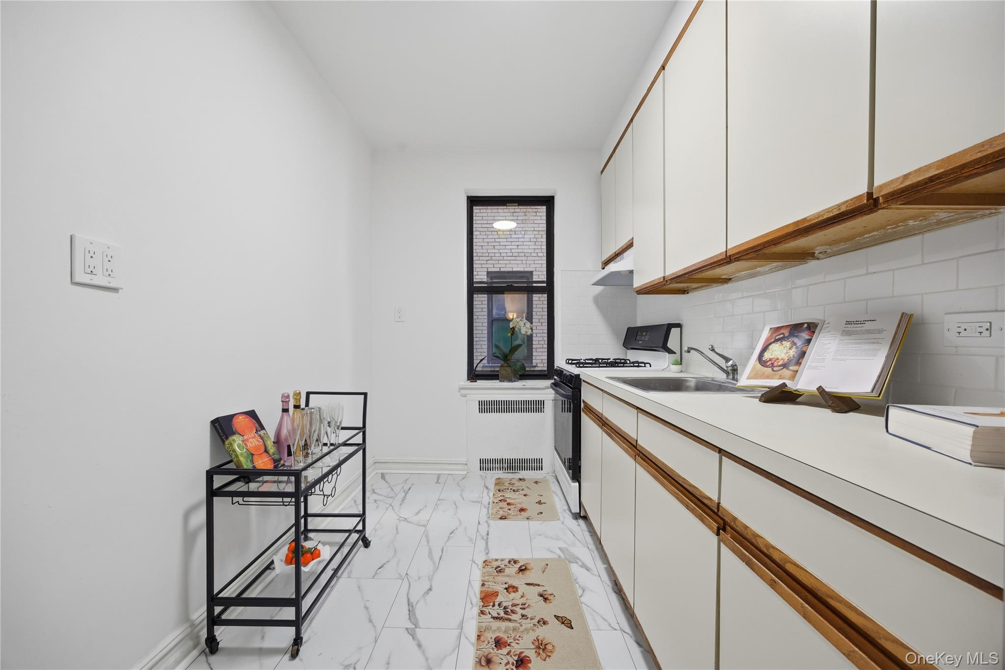 35-35 75th Street, Unit 324 Queens, NY 11372 - Photo 8 of 22 a kitchen with a sink and a stove top oven