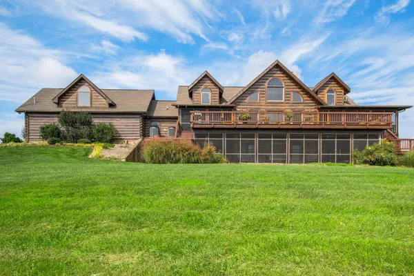 a view of a big house with a big yard and large tree