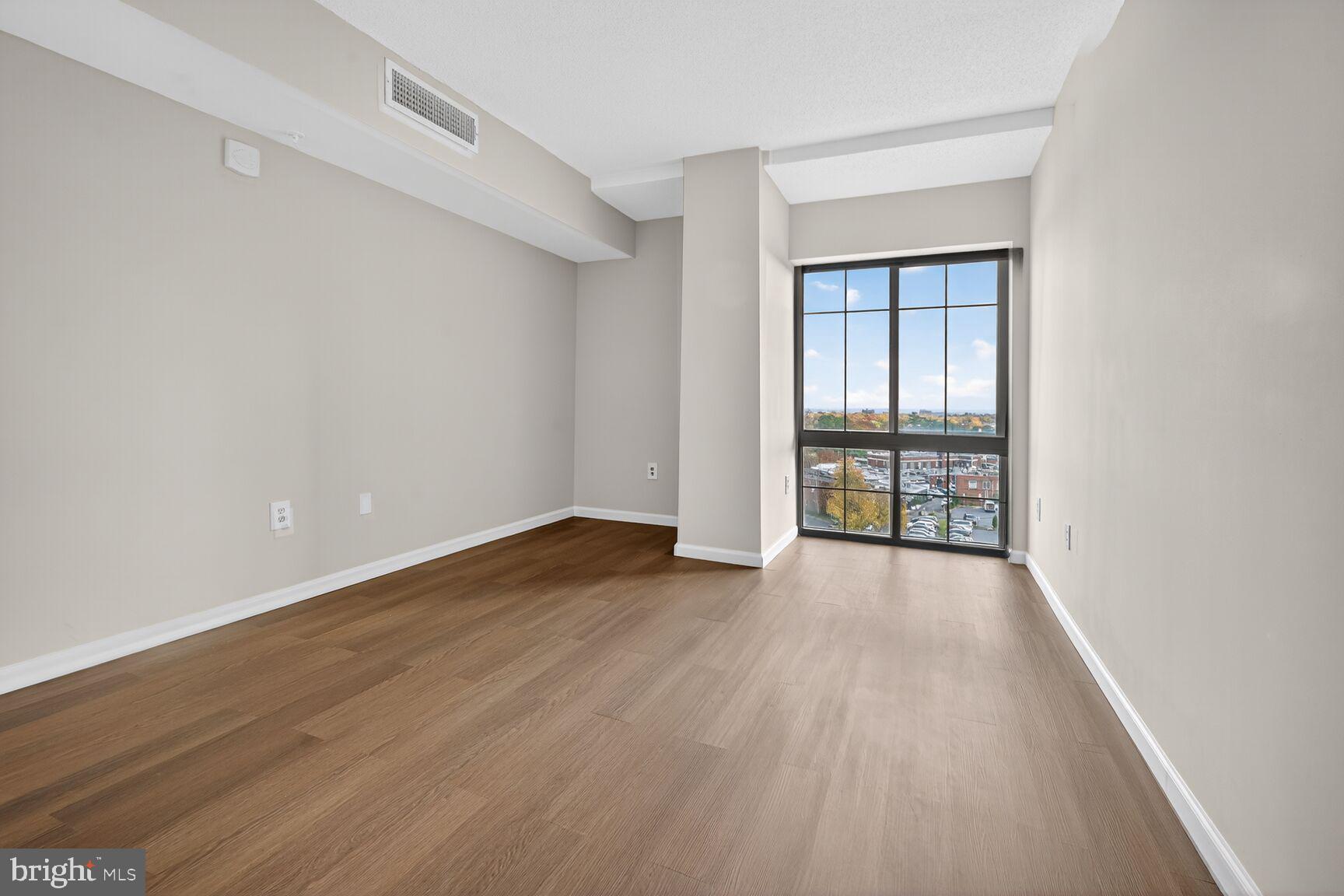 7915 Eastern Avenue Northwest, Unit 1114 Silver Spring, MD 20910 - Photo 13 of 34 wooden floor in an empty room with a window
