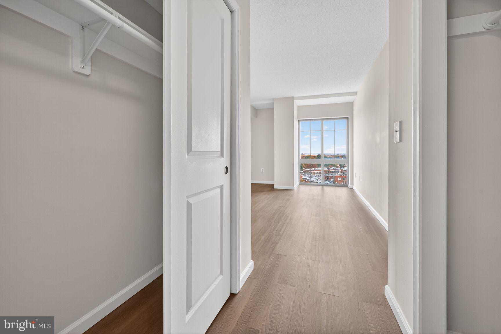 7915 Eastern Avenue Northwest, Unit 1114 Silver Spring, MD 20910 - Photo 15 of 34 a view of a hallway with wooden floor and a living room