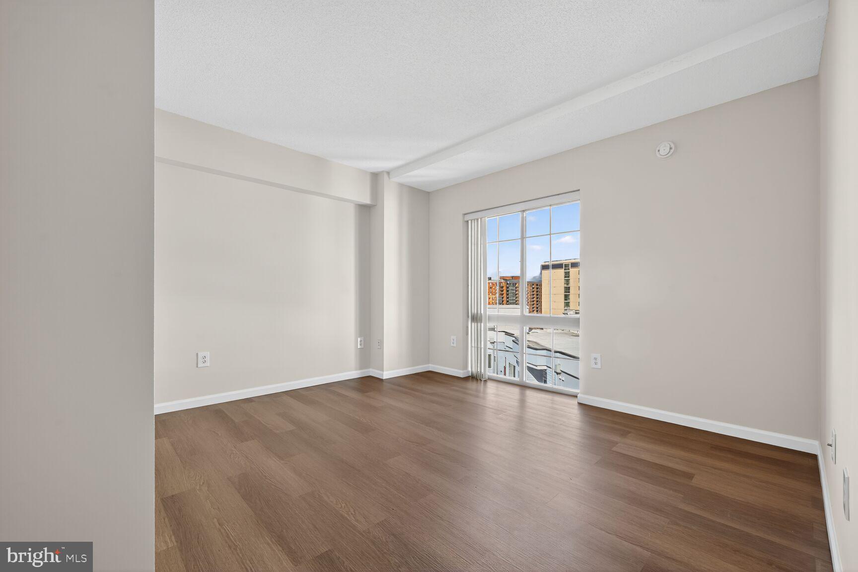 7915 Eastern Avenue Northwest, Unit 1114 Silver Spring, MD 20910 - Photo 17 of 34 an empty room with wooden floor and a window