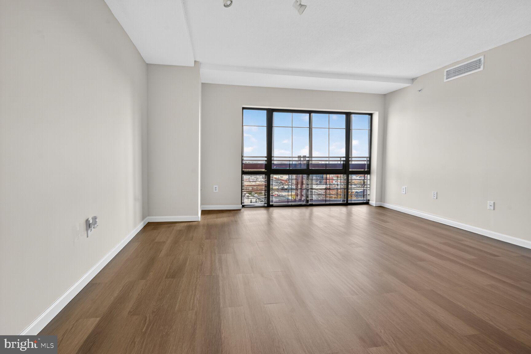 7915 Eastern Avenue Northwest, Unit 1114 Silver Spring, MD 20910 - Photo 8 of 34 wooden floor in an empty room with a window