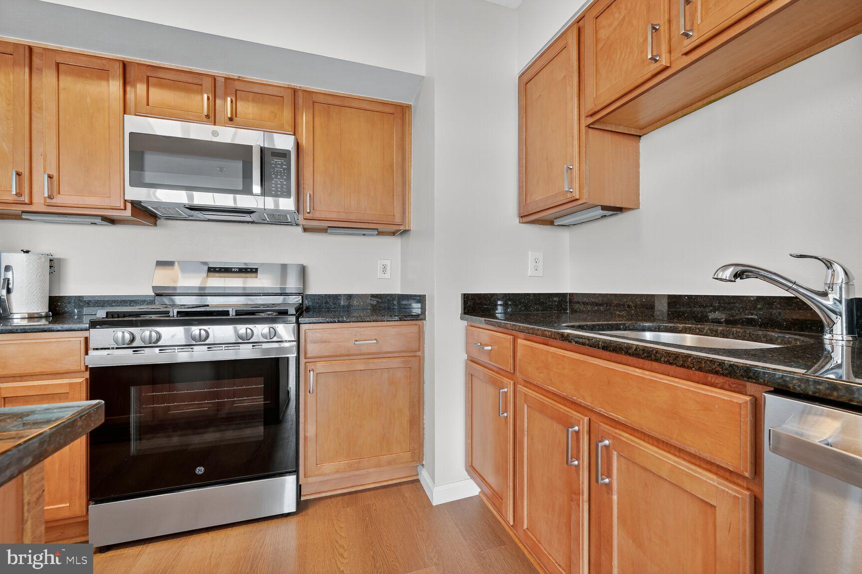 7915 Eastern Avenue Northwest, Unit 1114 Silver Spring, MD 20910 - Photo 9 of 34 a kitchen with stainless steel appliances granite countertop a stove and a microwave