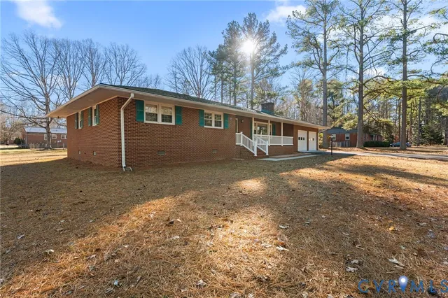 a front view of a house with a yard and trees