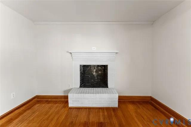 a view of wooden floor in an empty room with a fireplace