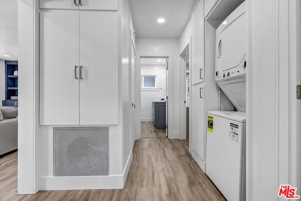a view of hallway with walk in closet and wooden floor