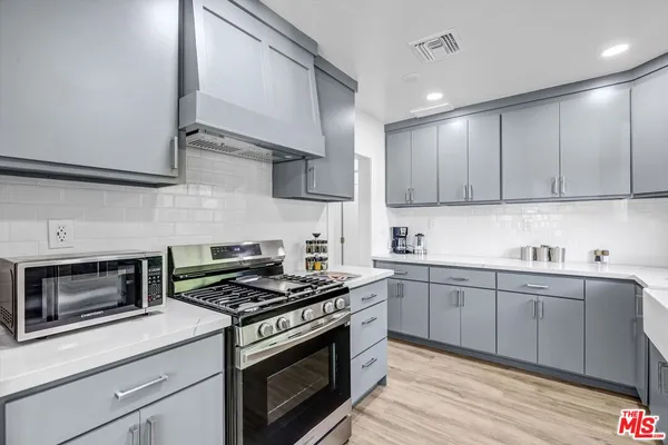 a kitchen with stainless steel appliances granite countertop a stove and a sink