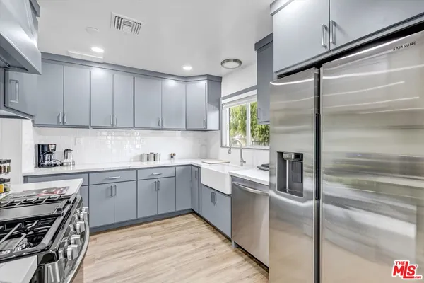a kitchen with a sink stainless steel appliances and cabinets