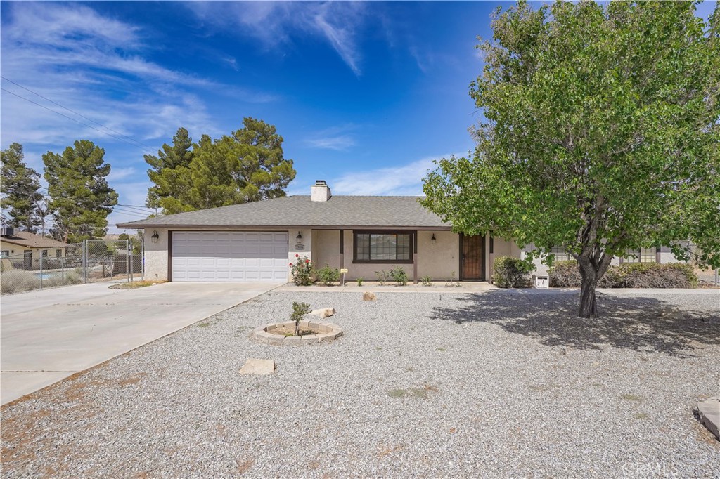 15084 Tacony Road Apple Valley, CA 92307 - Photo 1 of 1 a front view of a house with a yard and trees