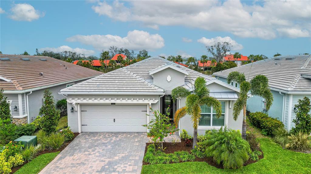 5721 Long Shore Loop Sarasota, FL 34238 - Photo 1 of 1 a front view of a house with a yard and potted plants