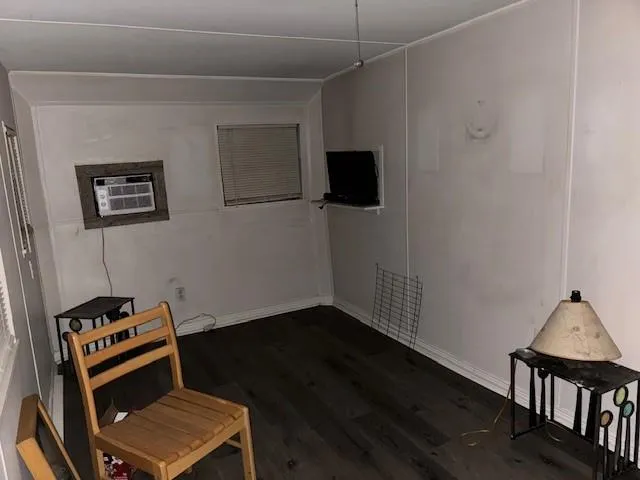 a view of room with wooden floor and black appliances