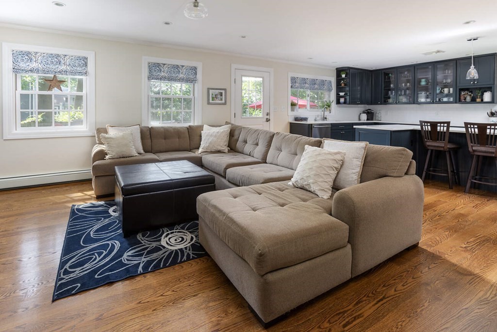 25 Plowgate Road Brookline, MA 02467 - Photo 5 of 19 a living room with furniture a wooden floor and kitchen view