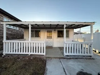 a view of a porch with a wooden floor chairs