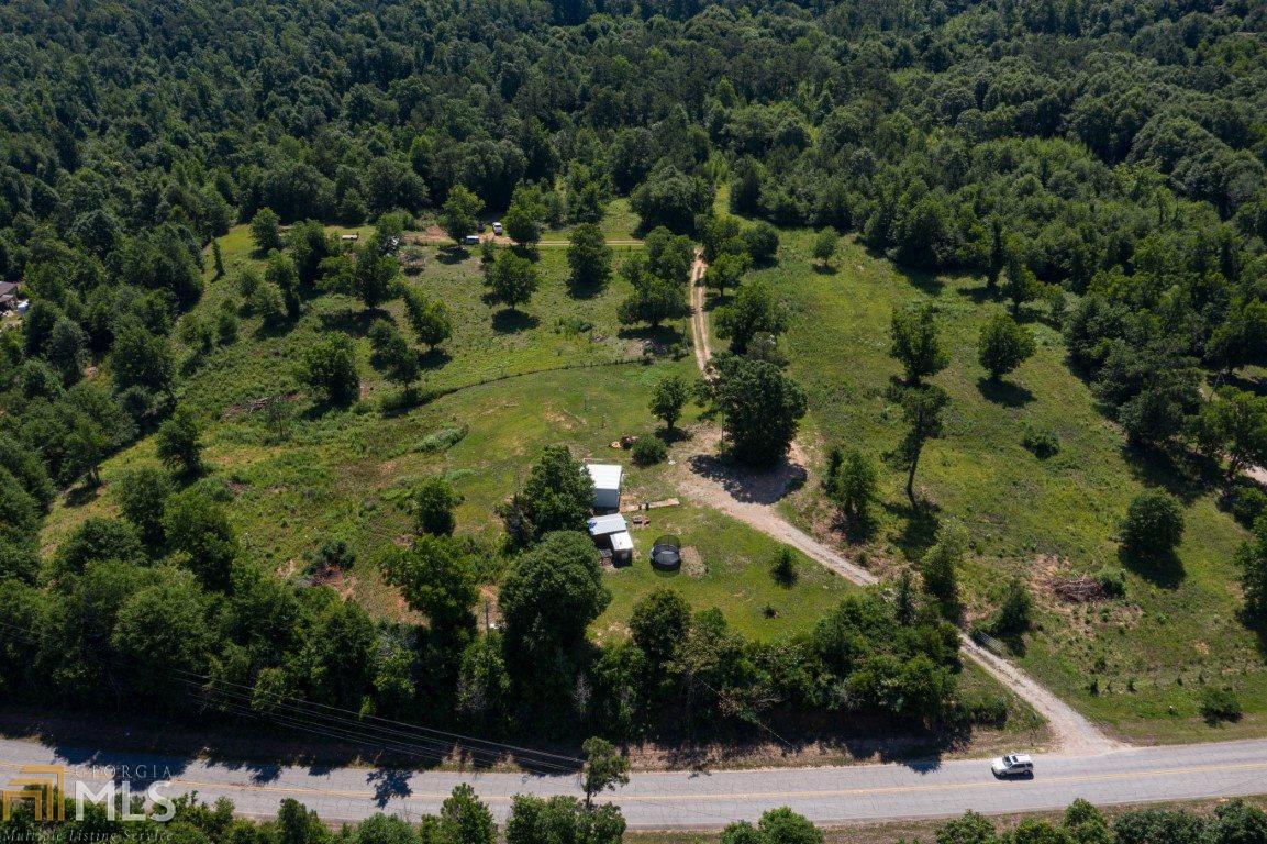 an aerial view of residential houses with outdoor space and trees