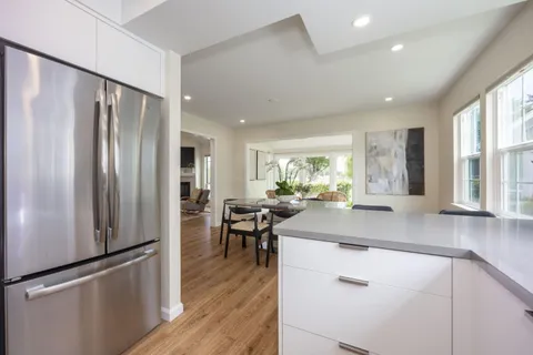 a kitchen with stainless steel appliances granite countertop a refrigerator and a stove top oven