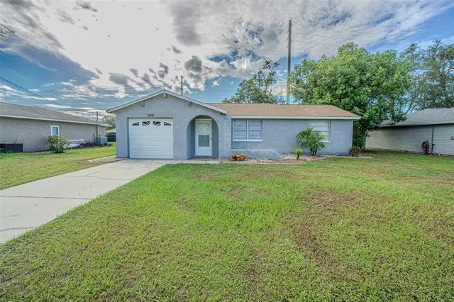 a front view of a house with a garden and yard