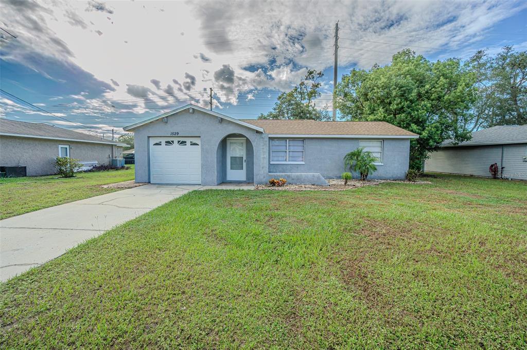a front view of a house with a garden and yard