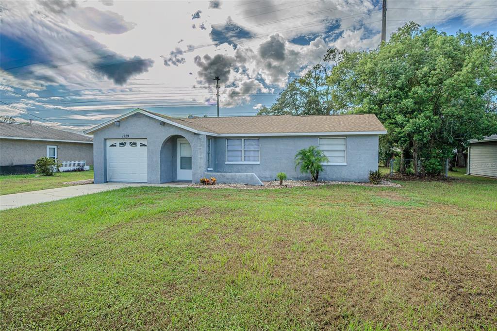 1529 Larkin Road Spring Hill, FL 34608 - Photo 11 of 37 a front view of a house with a garden