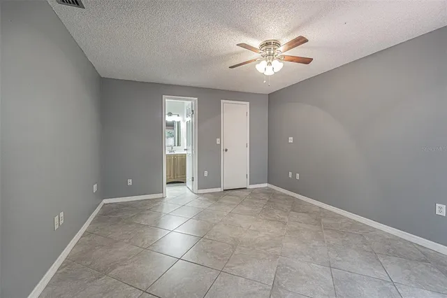 a view of an empty room with a ceiling fan