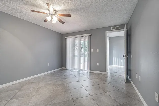 a view of an empty room with a chandelier fan