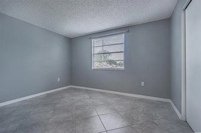 an empty room with windows and closet