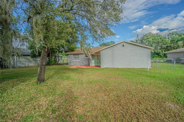 a view of a house with backyard and tree